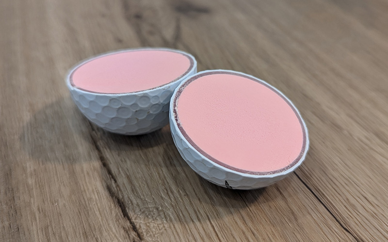 3 piece golf ball cut in half so you can see the 3 layers